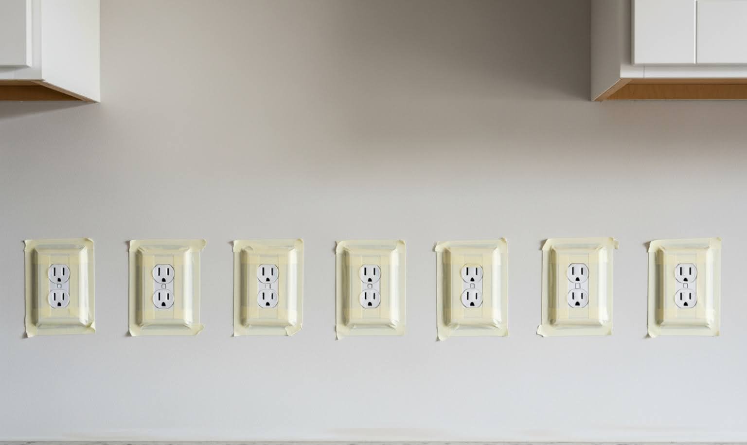 clean, prepped kitchen wall with outlets taped over - how to install stone tile backsplash in kitchen