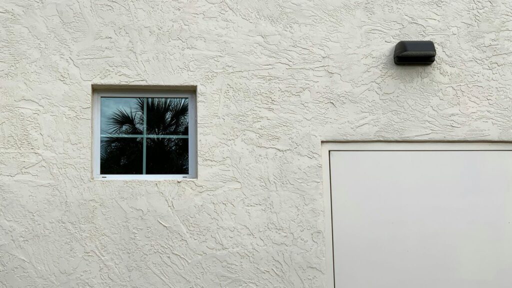 a white building with a window and a white door