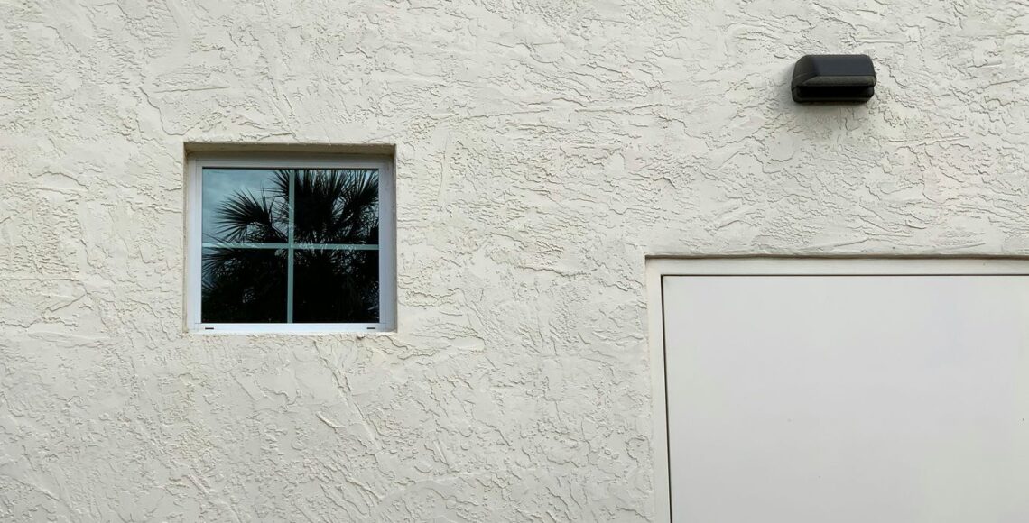 a white building with a window and a white door